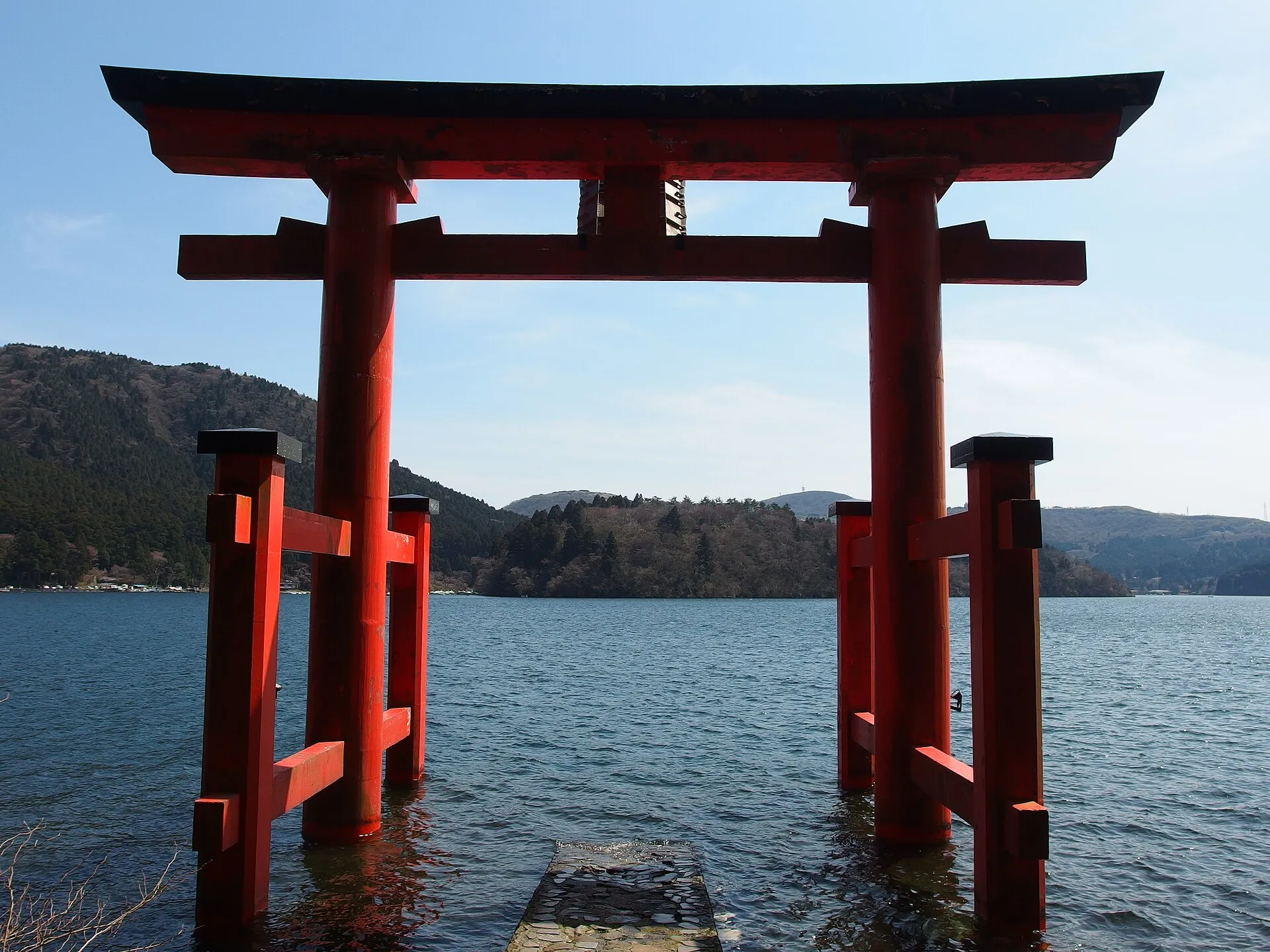 Red torii gate of Hakone Shrine standing in Lake Ashi